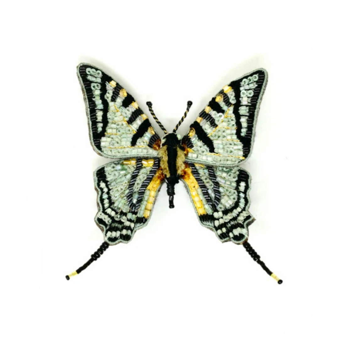 Hand embroidered and beaded butterfly brooch. Butterfly is black and white with touches of yellow on it's wings and body. Wings are covered in white and yellow beads and micro sequins. The "swallowtail" effect of the wings is accomplished with black beads with yellow beads at the tips.
It's a very magical butterfly.