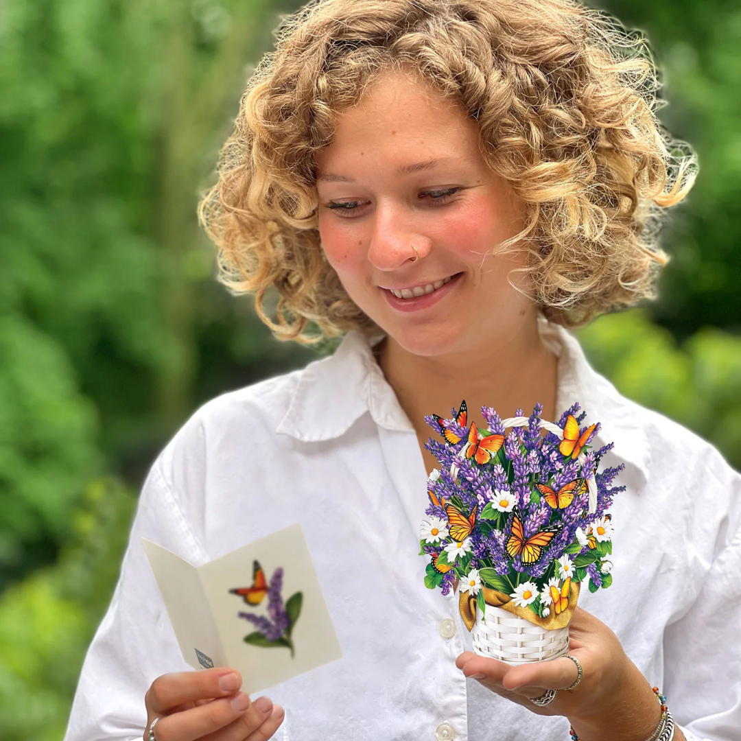 Woman holding the bouquet in one hand and the included note card in the other