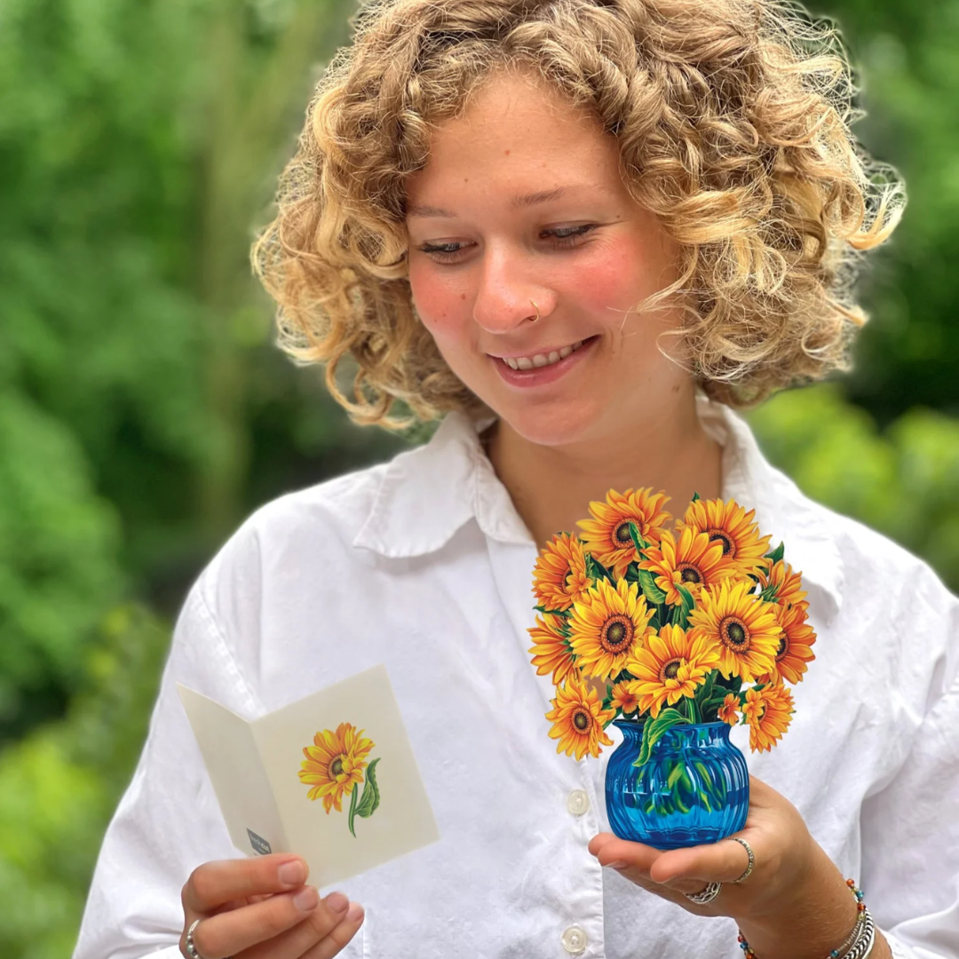 Woman holding the Sunflower bouquet and the included card.