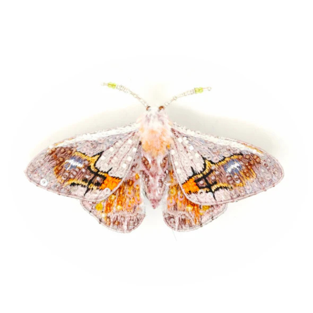 Hand embroidered and beaded brooch of a white, brown, yellow, and orange moth. The moth's wings are covered in white beads and clear sequins with brown and orange beads in the moth's markings. The moth has a fuzzy body and antenna made of clear and yellow beads.
It's hauntingly beautiful.