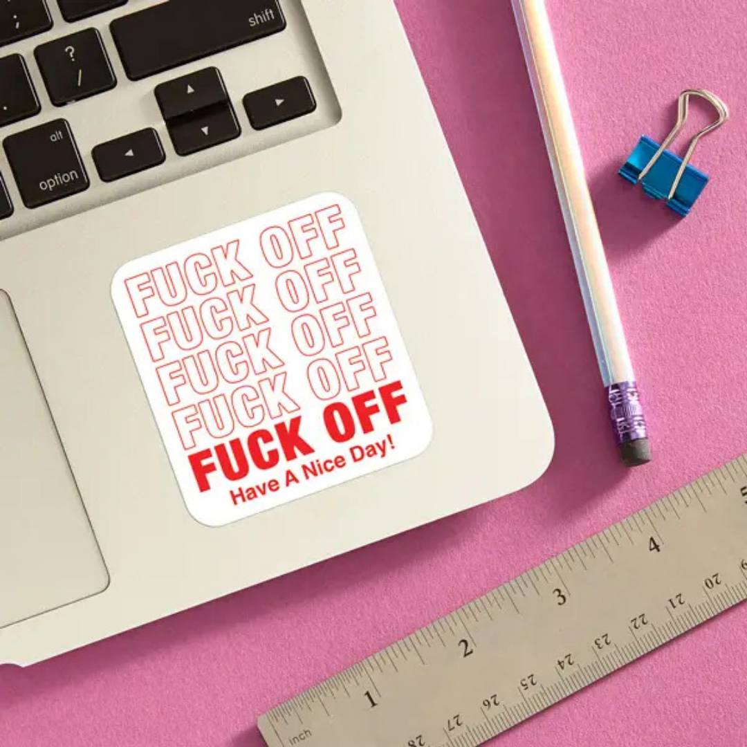 Fuck off sticker on a laptop with a pencil and a ruler for scale