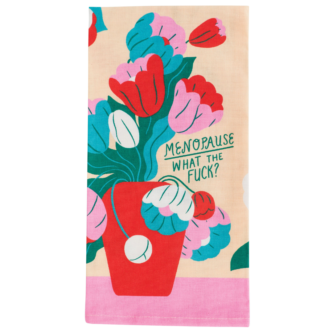 Folded tea towel with a red pot of pretty flowers. Alongside the flowers are the words "Menopause what the f*ck?"