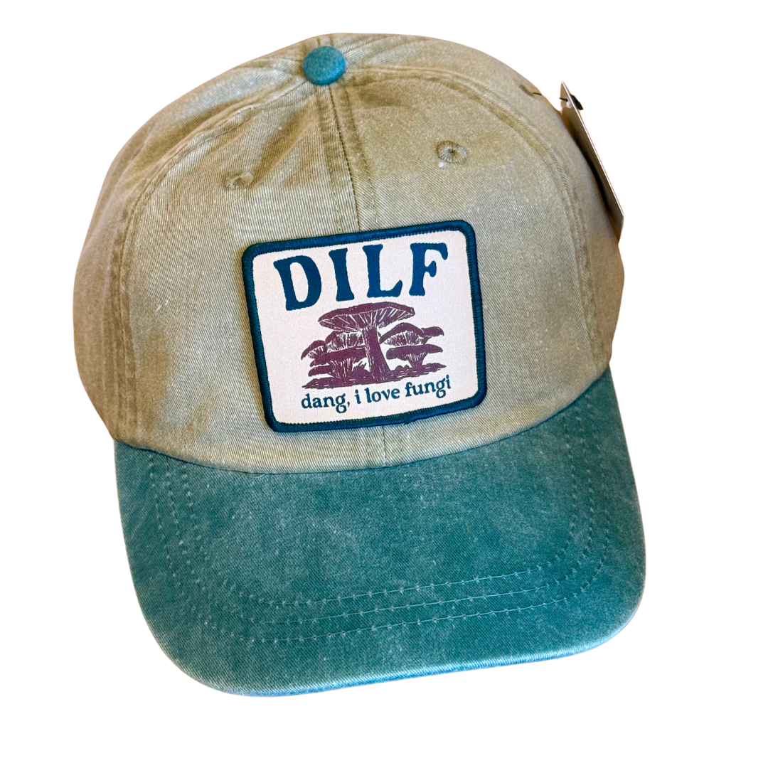 Dang, I love fungi cap. The crown is khaki with a forest green button on top. The bill of the cap is forest green. The cap has a patch that has mushrooms and reads "DILF/dang,i love fungi"