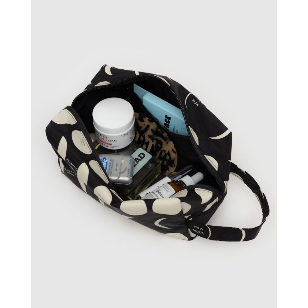 Toiletry travel pouch in black featuring a moon pattern all over.