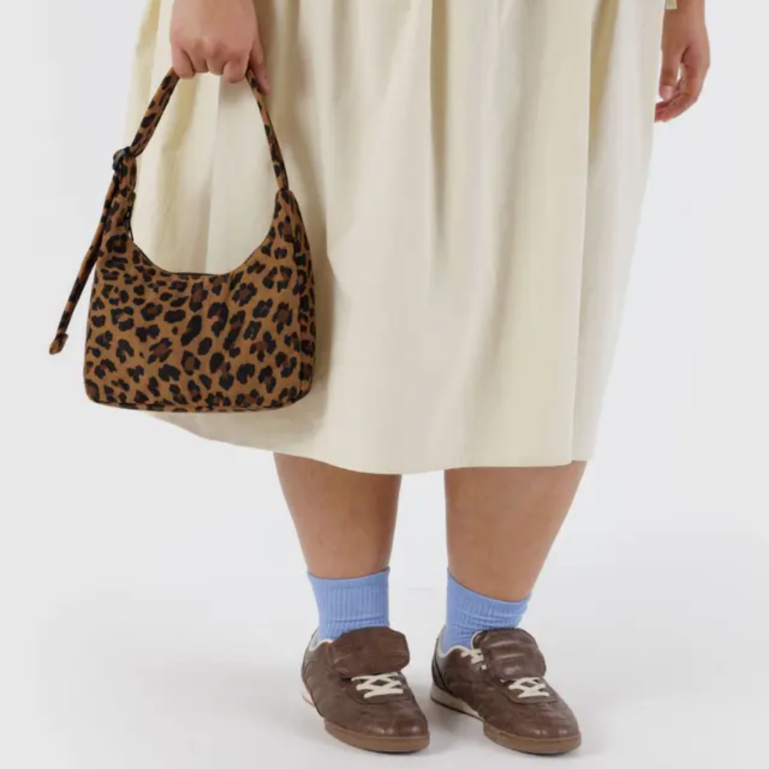 Model holding the bag by the strap for scale.