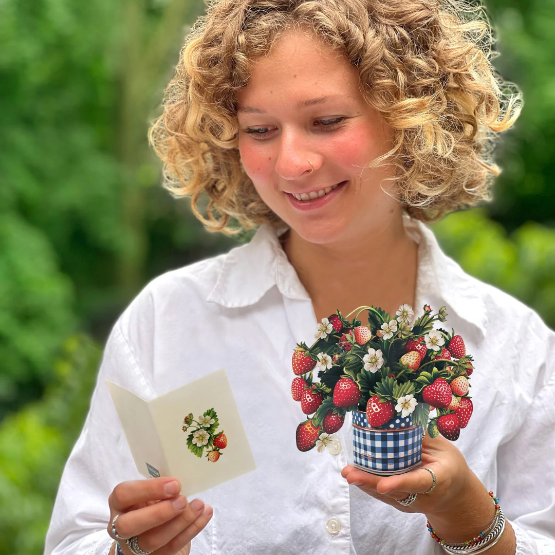 Woman holding the bouquet in one hand and the included card in the other