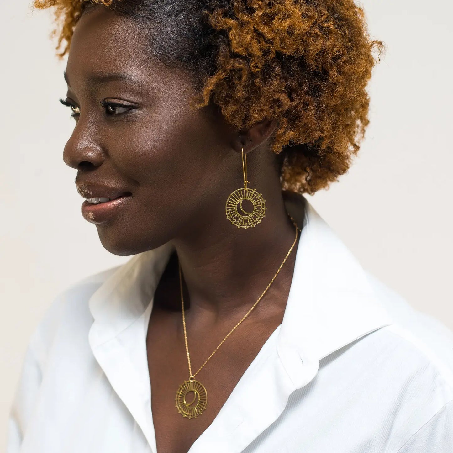 woman wearing gold earrings and matching necklace