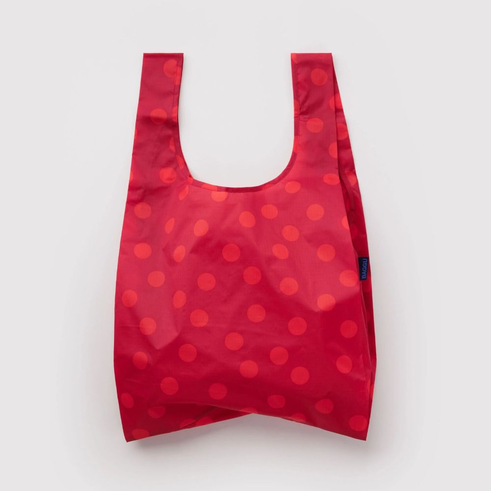 A reusable plastic bag in red with a pattern of darker red polka dots, shown against a plain light gray background.