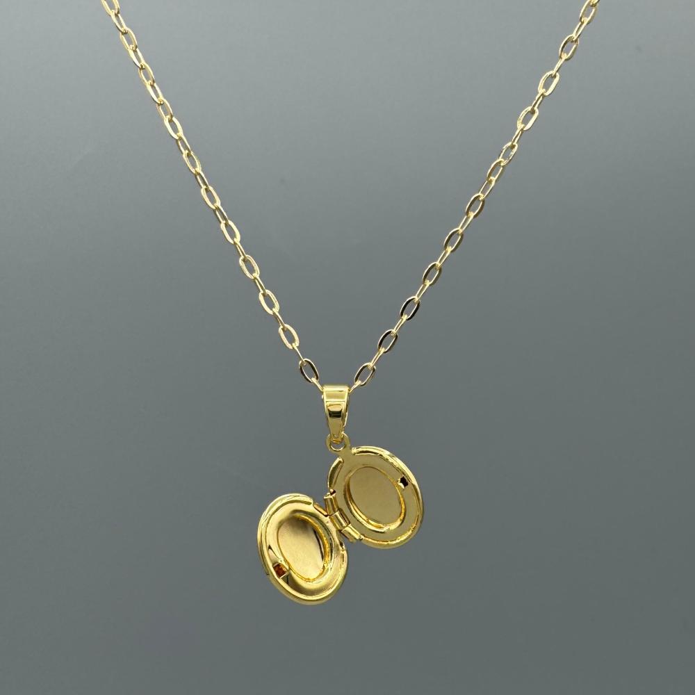 Gold necklace with a locket pendant on a gray background