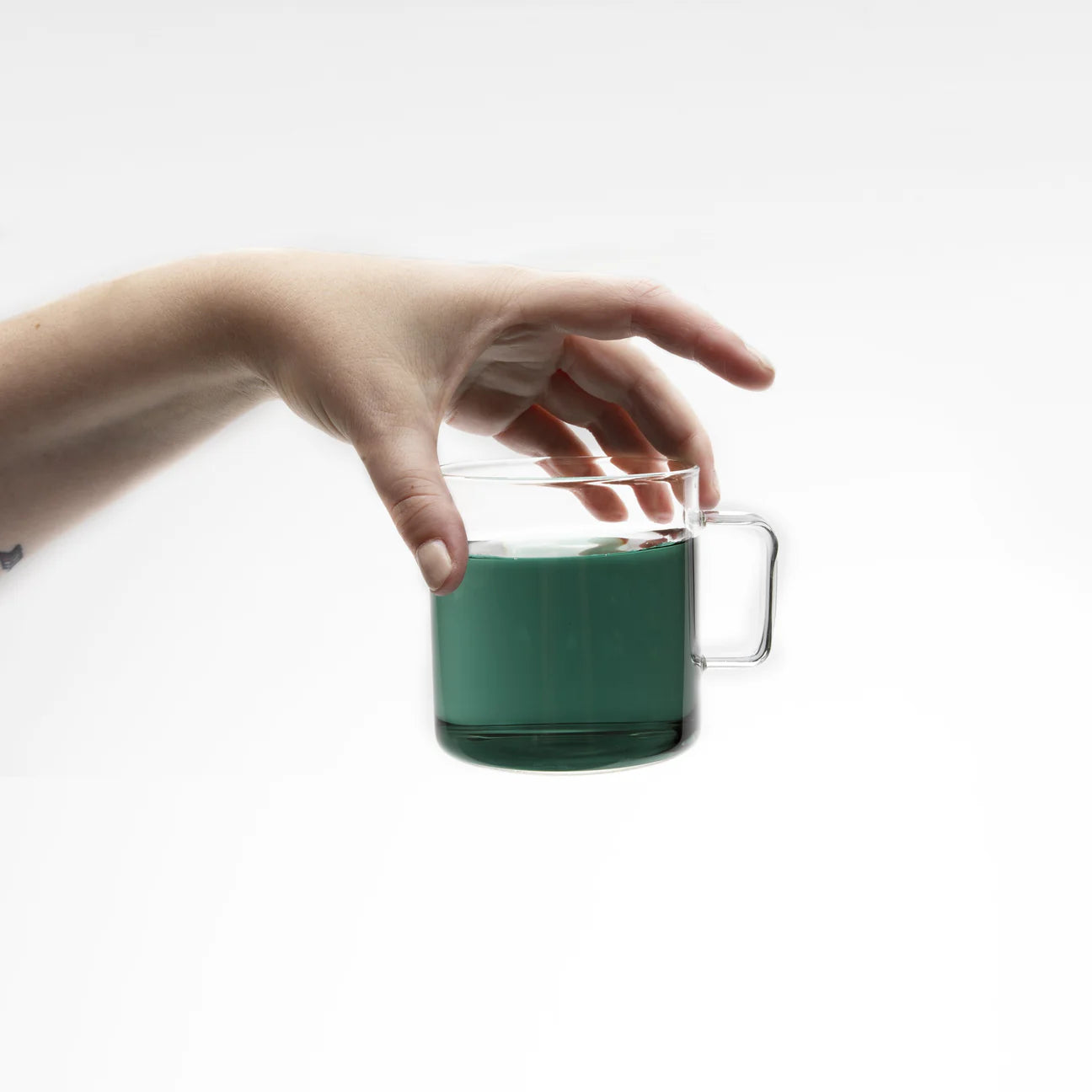Hand holding a cup of blue tea