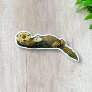 Adorable sea otter sticker with a white boarder. Otter is looking right at you and showing off the cool shell they have on their tummy!
Did you know sea otters have pockets in their arm pits?