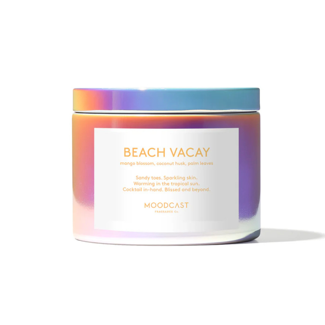 iridescent covered jar with a label reading "Beach Vacay - mango blossom, coconut husk, palm leaves
Sandy toes. Sparkling skin. Warming in the tropical sun. Cocktail in-hand. Blissed and beyond.
Moodcast"