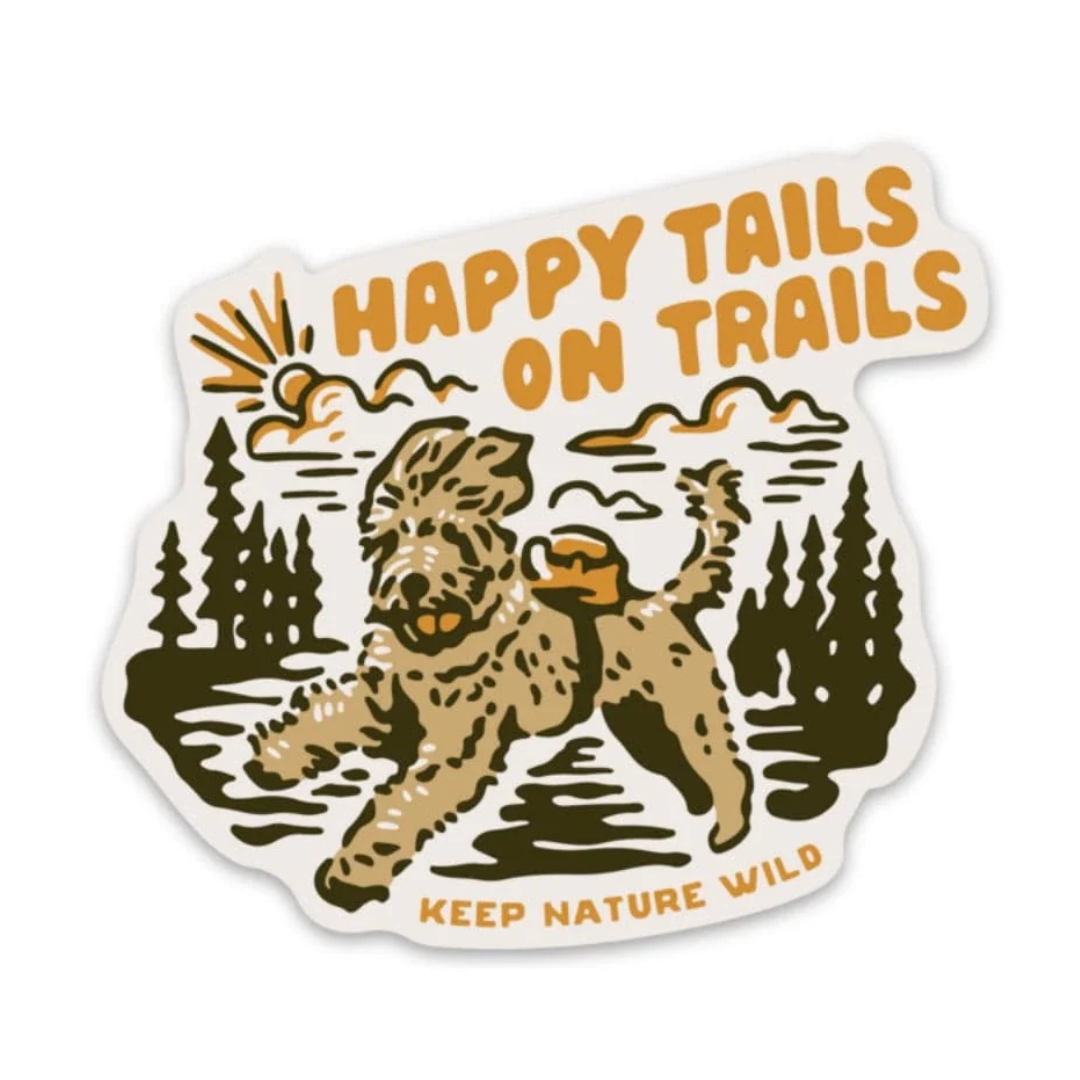 Adorable fluffy doodle dog holding a ball and wearing a backpack frolics in the sunny wild. Sticker reads "Happy tails on trails/Keep nature wild"
