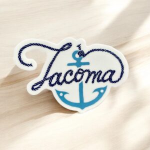 Tacoma sticker has a light blue anchor and the word "Tacoma" spelled out in script with the anchor's rope on a white background