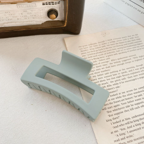 Light blue rectangular object on a book with a vintage radio in the background