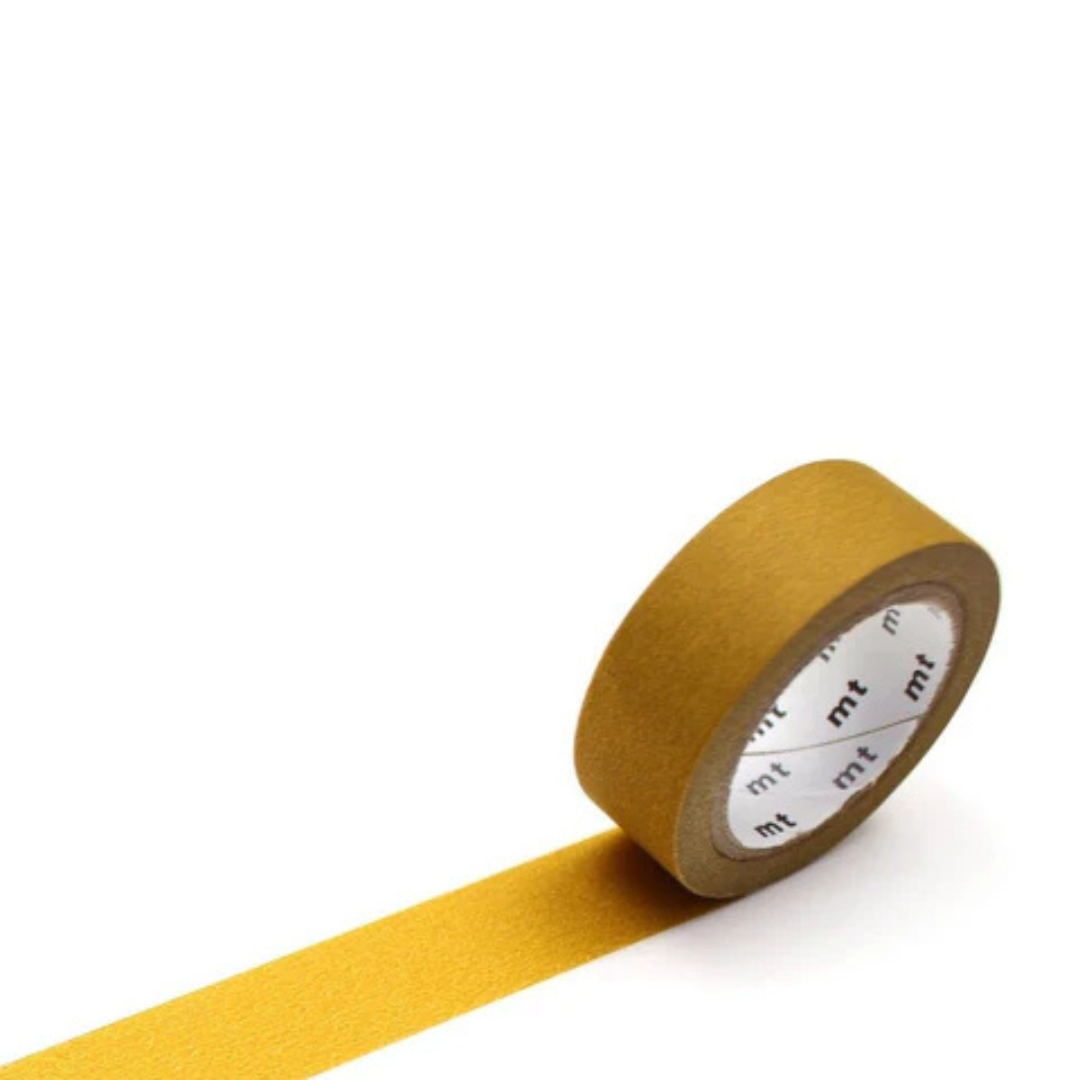 Matte mustard roll of masking tape against a white background.