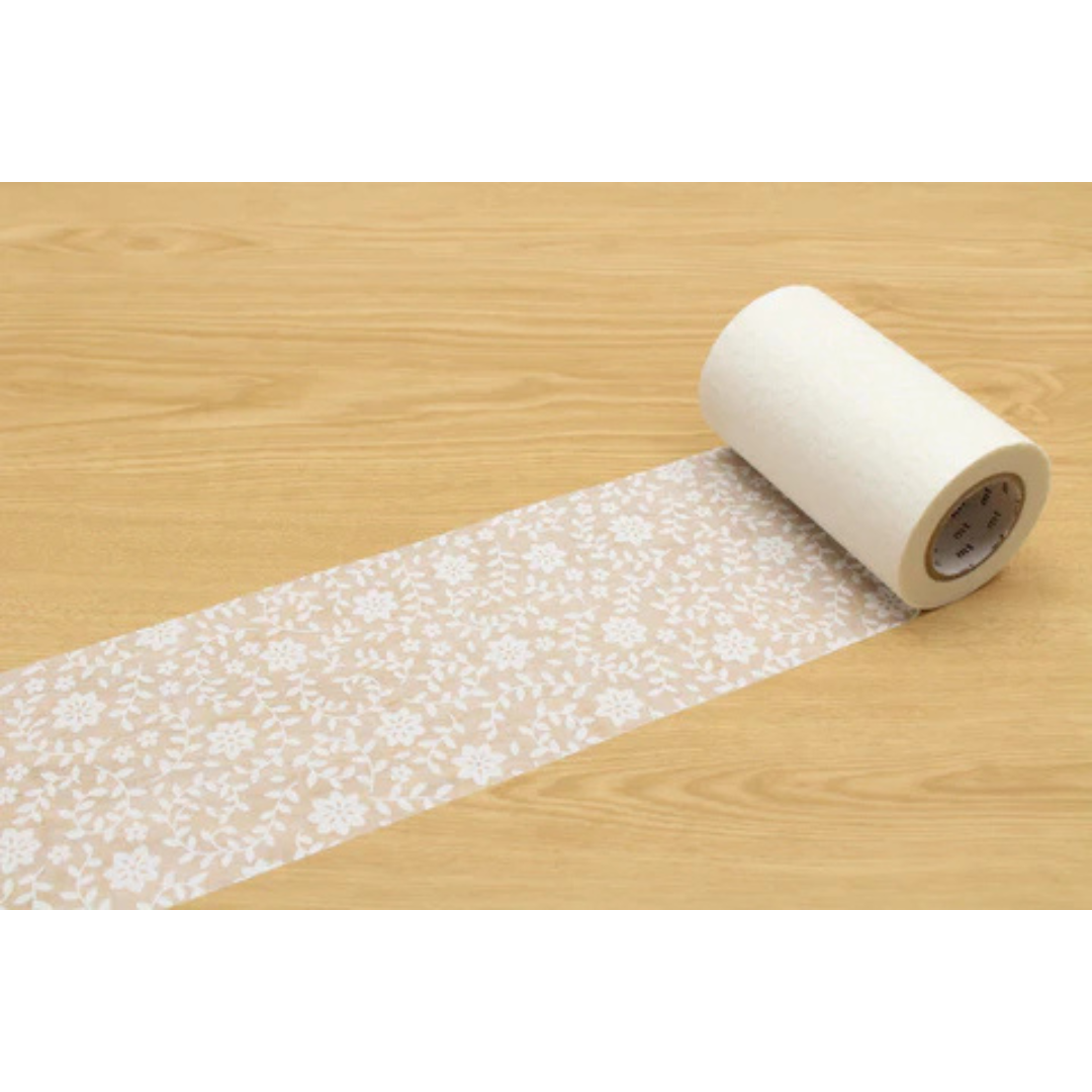 Beige and white floral roll of tape against a wood grained table.