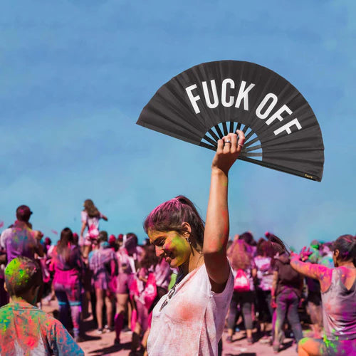 Model holding the fan above their head at a color festival