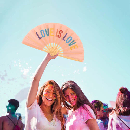 Pair of festival goers smiling with the XXL Love is Love fan