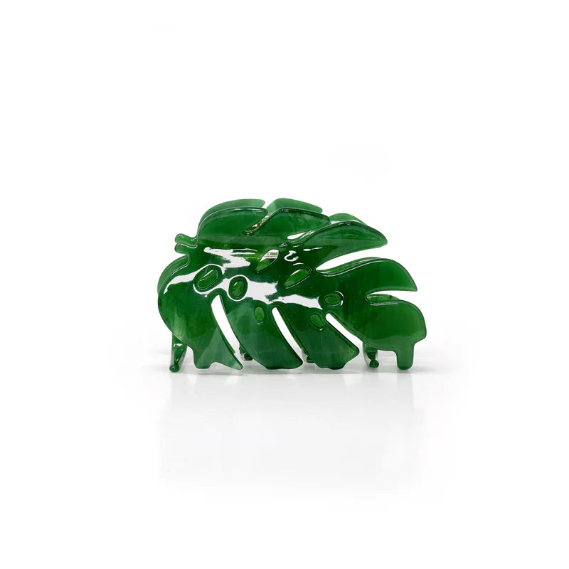 A green claw-style hair clip shaped like a monstera leaf.