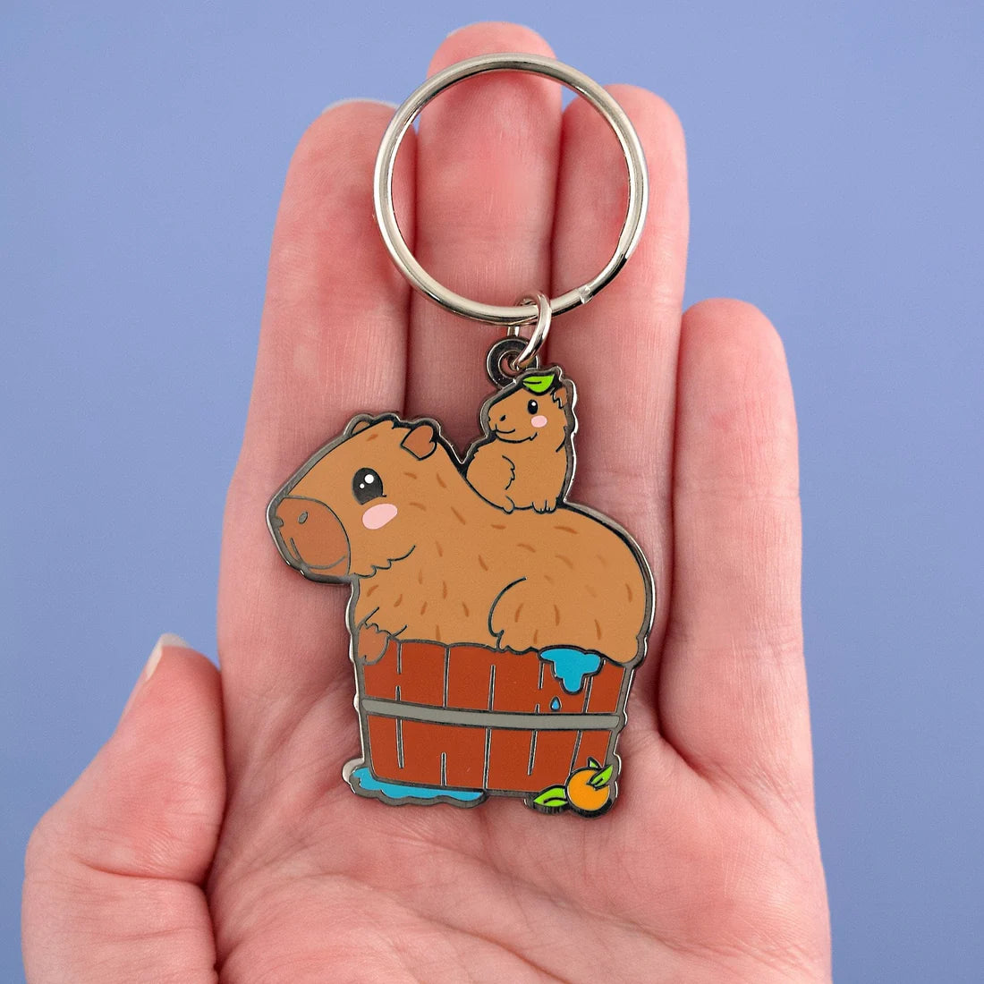 Hand holding the capybara keychain for scale.