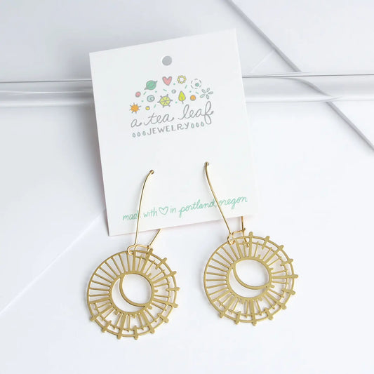 gold earrings with moon shape and sun rays on a card with A Tea Leaf logo