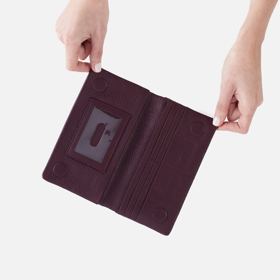two hands holding open a red wine colored wallet