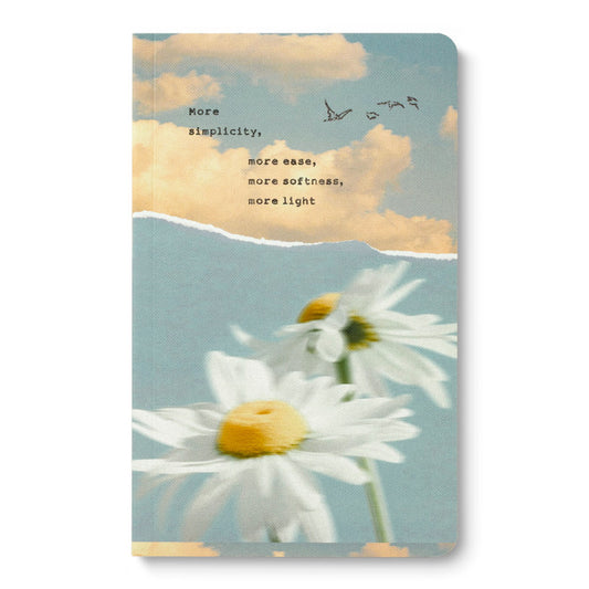 Notebook with a sky and daisies says "More simplicity, more ease, more softness, more light