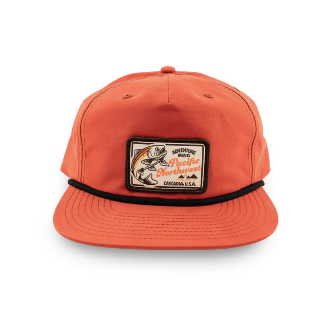 Orange ball cap style hat with brown trim and a fish themed patch that says "Adventure Awaits Pacific Northwest Cascadia, USA"