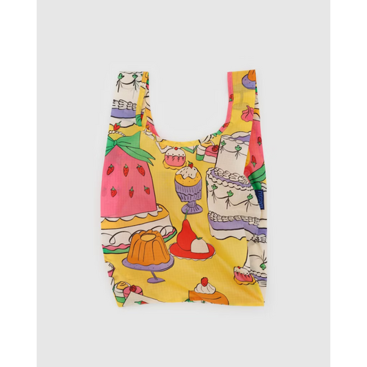 Yellow reusable tote bag featuring a dessert print with different types of cake all over.