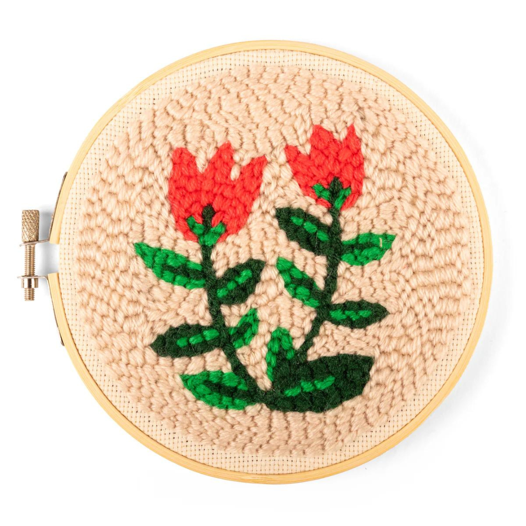 Completed punch needle kit featuring a beige background with red tulips and multi-toned green stems.