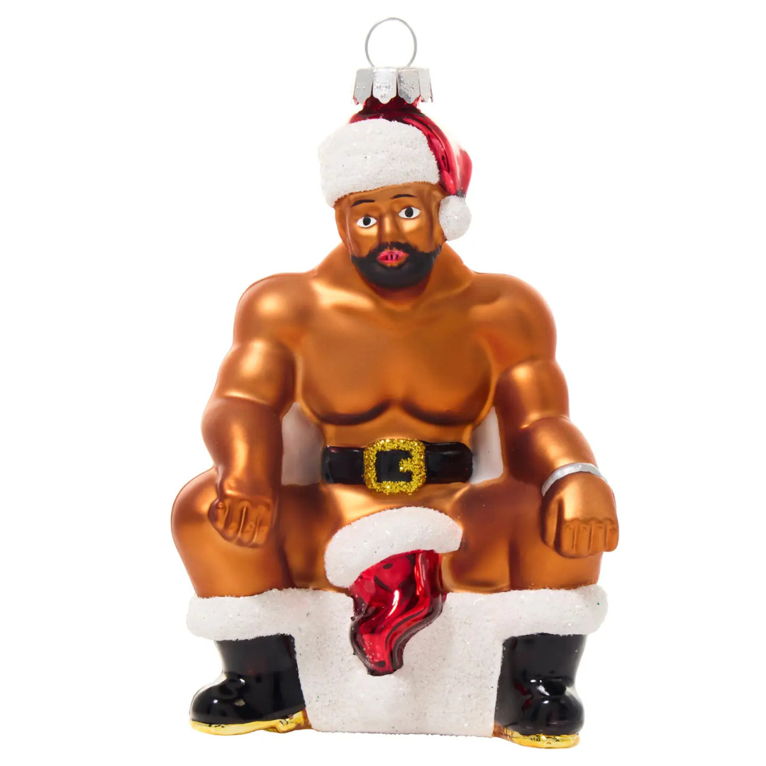 Ornament of a black man wearing only a Santa hat, black belt and black boots with a red Christmas stocking covering his genitalia.