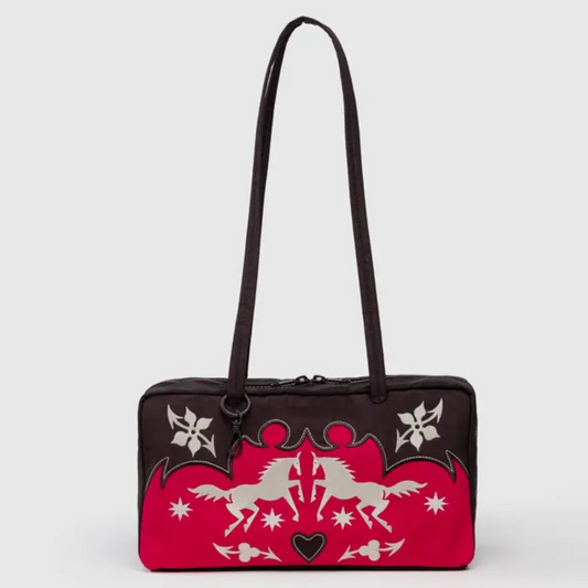 Baggu bowler bag is a rectangular bag with long straps. It is decorated in a western motif with horses, stars, and flowers in black, red, and white with white topstitching.
