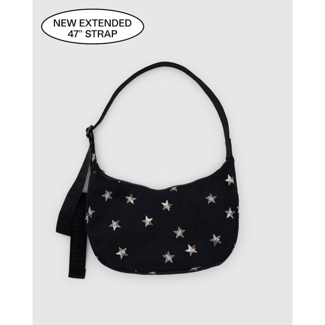 Black nylon bag in a crescent shape featuring an all over silver starts pattern and a black strap.