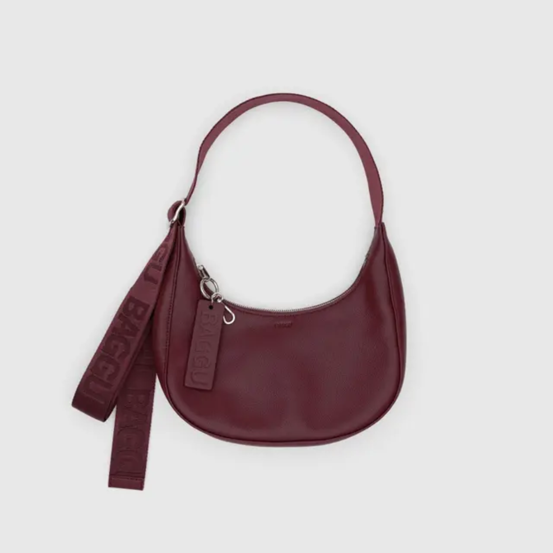 Crescent shaped maroon leather bag with adjustable nylon strap