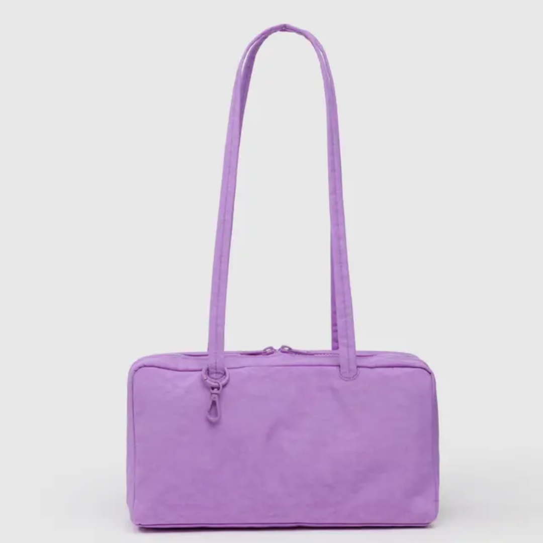 Baggu bowler bag is rectangular with long shoulder straps. Bag is in a pinkish lavender. 