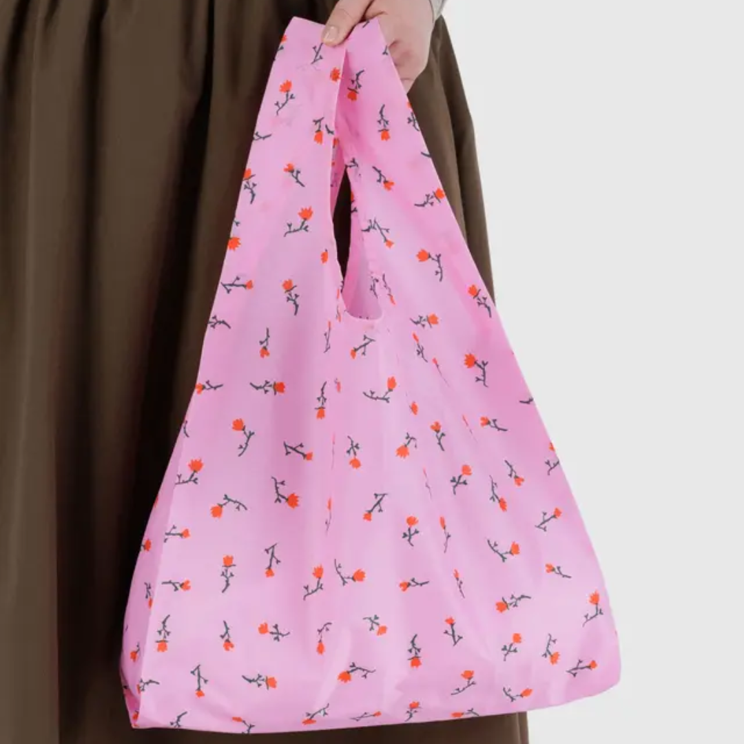 Model holding a pink reusable bag with floral pattern