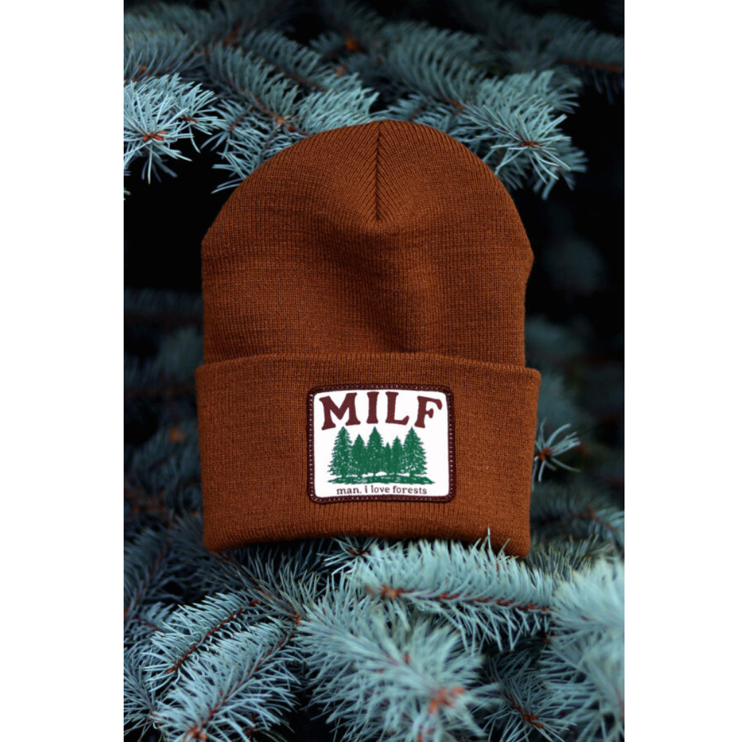 Rusty brown beanie with a white rectangular patch featuring green trees and the words "MILF" and "man I love forests".