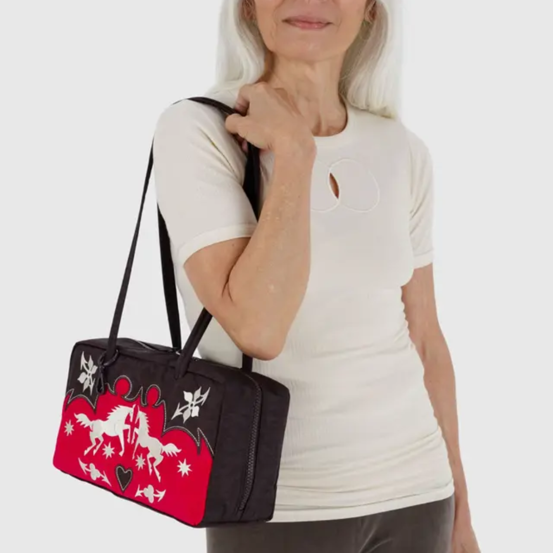 Model wears the Baggu bowler bag on their shoulder.
