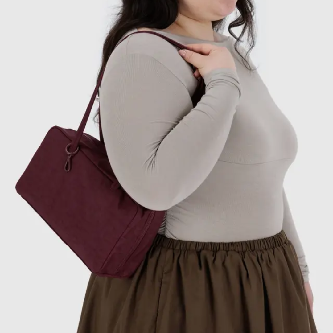 Model with the Baggu bowler bag on their shoulder. The bag falls at their waist.