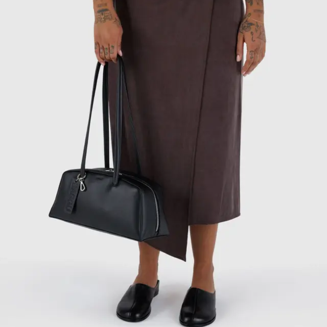 Model holds bowler bag by the strap