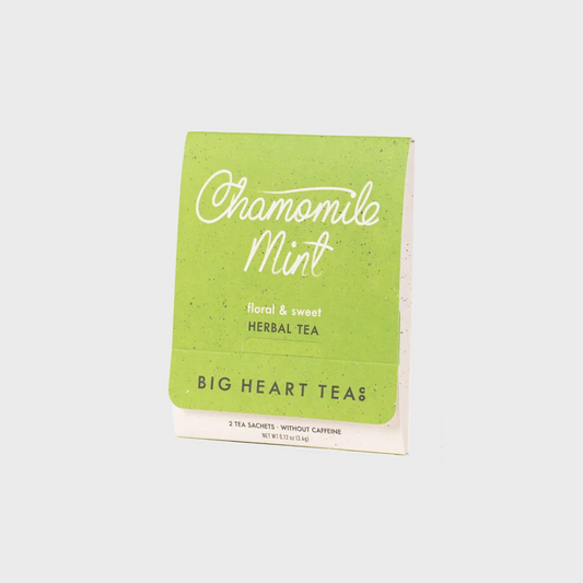 Tea bag with a lime green label featuring the flavor "Chamomile Mint" in white cursive and the words "floral & sweet herbal tea" above the brand name "Big Heart Tea Co" in black lettering.