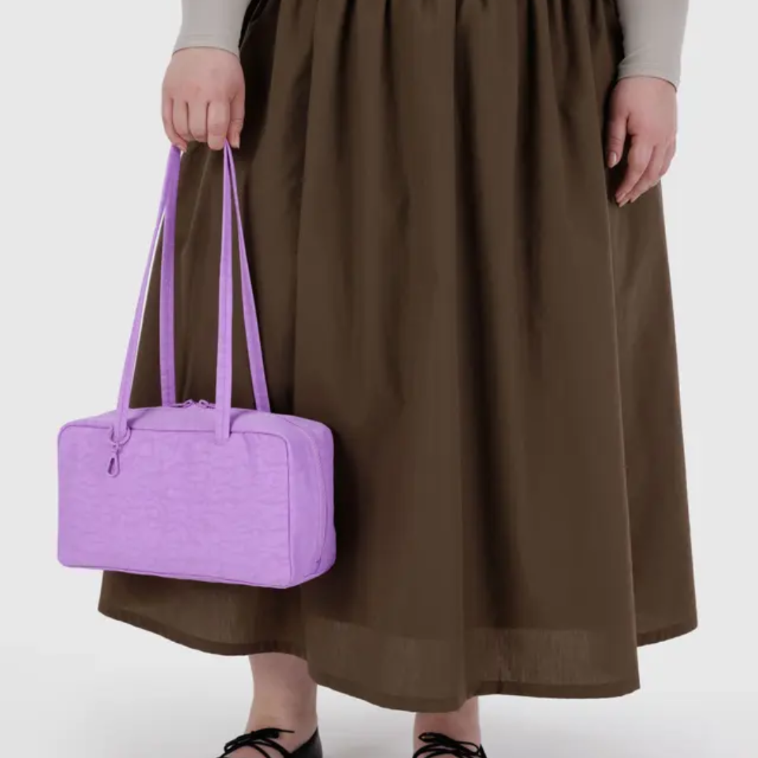 Model holding the Baggu bowler bag by the strap