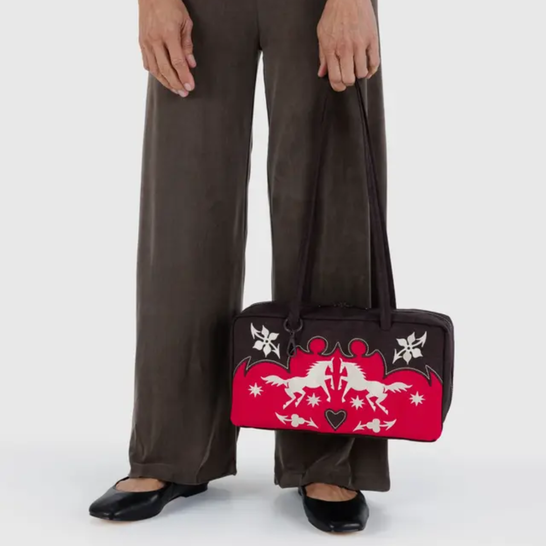 Model holds the Baggu bowler bag by the strap