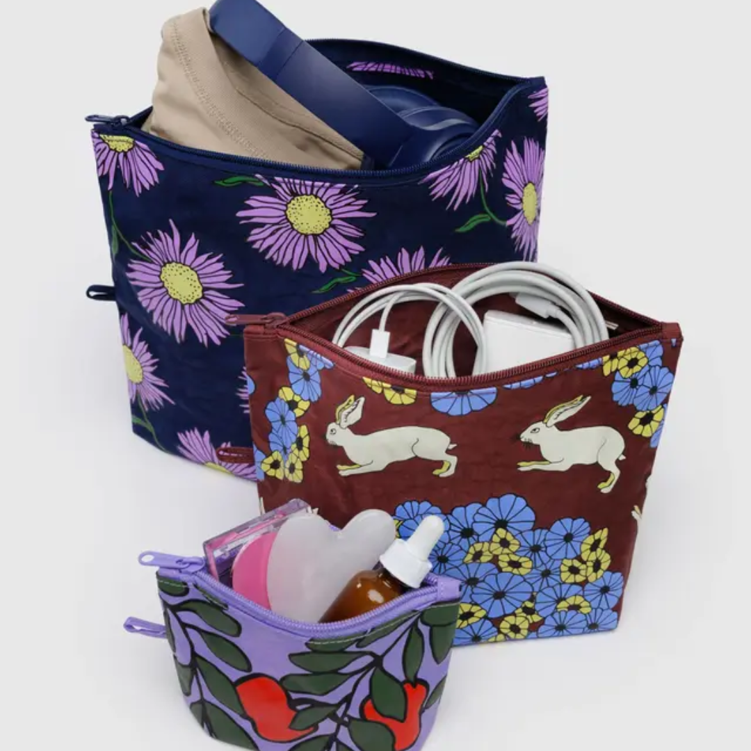 Set of three floral-patterned bags with various items inside them