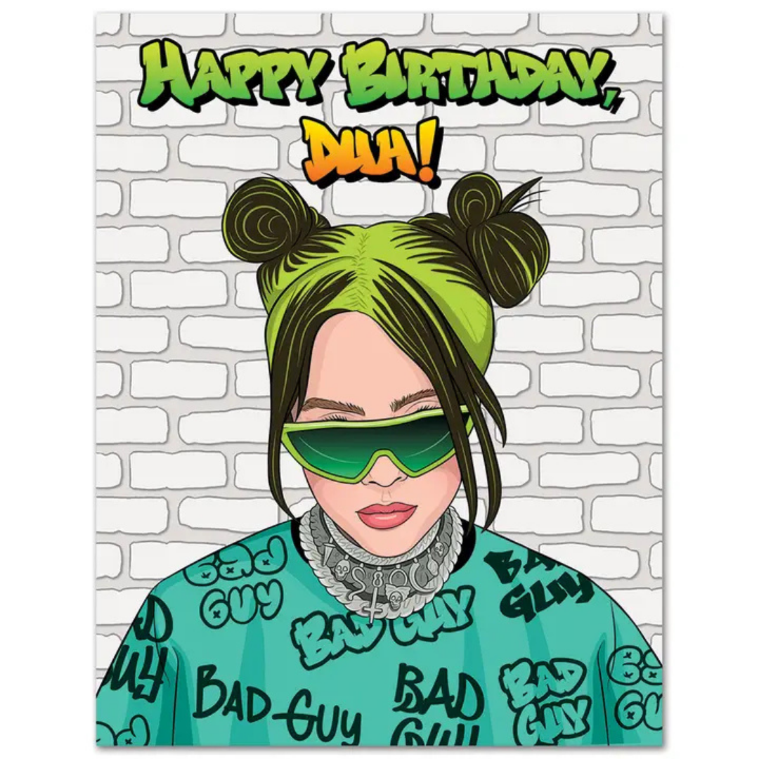 Billie Eilish woth green and black hair in two buns, wearing green sunglasses and a green shirt that says "bad guy all over it stands against a white brick wall with "Happy Birthday, DUH!" written in graffiti font