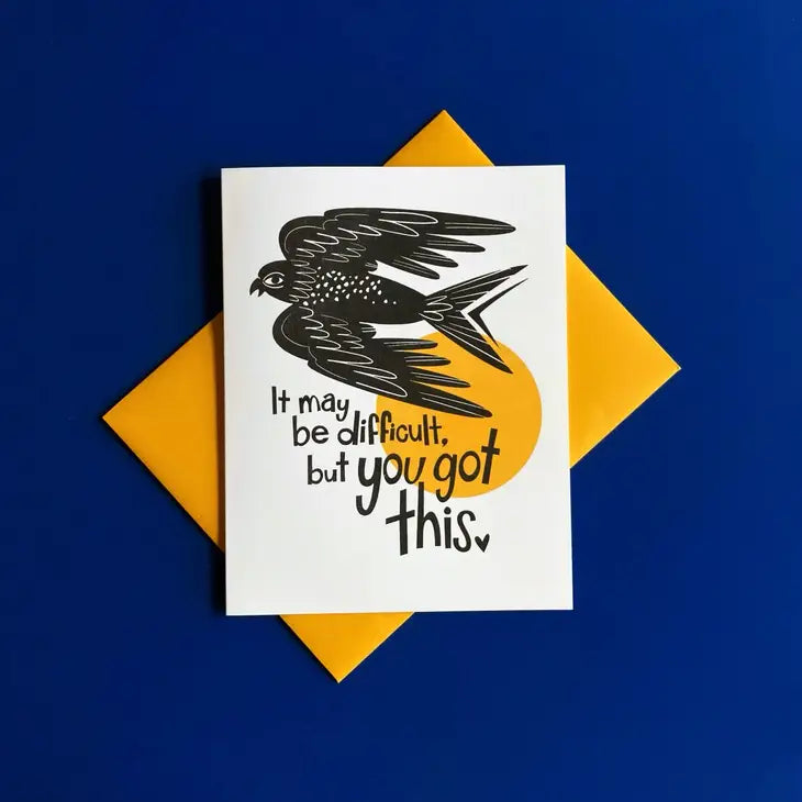 blue background with yellow envelope underneath white card, print of black bird and text reading "it may be difficult, but you got this"
