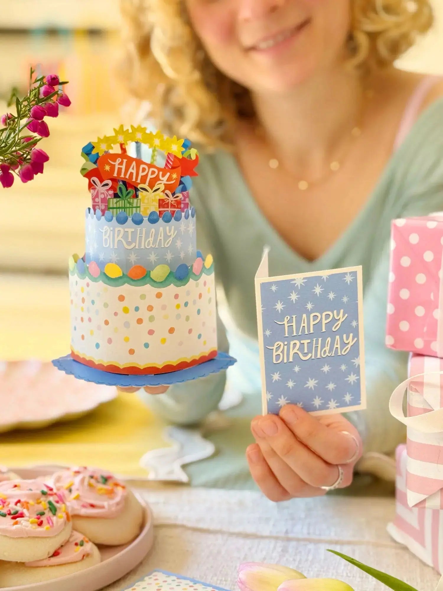 Person holding the pop-up birthday cake and the note card