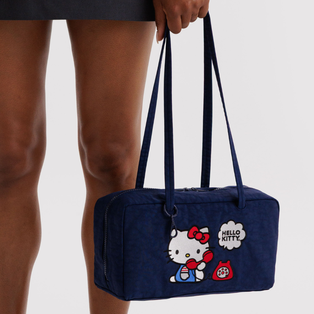 Model holds the Hello Kitty bag by the strap