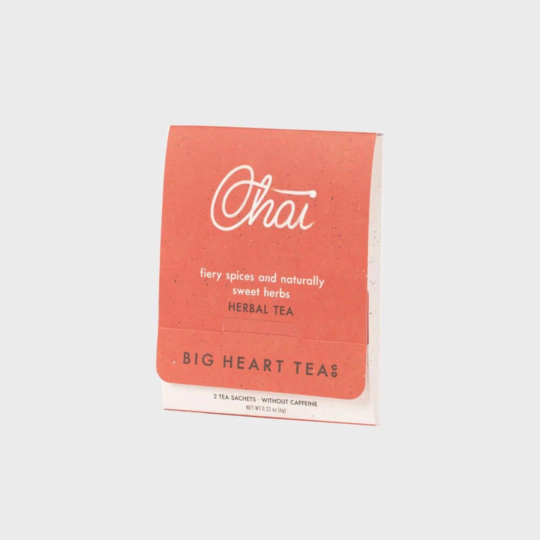 White tea bag with a coral colored label featuring the flavor "Chai" in white cursive above the words "fiery spices and naturally sweet herbs" and the brand name "Big Heart Tea Co" in black lettering.